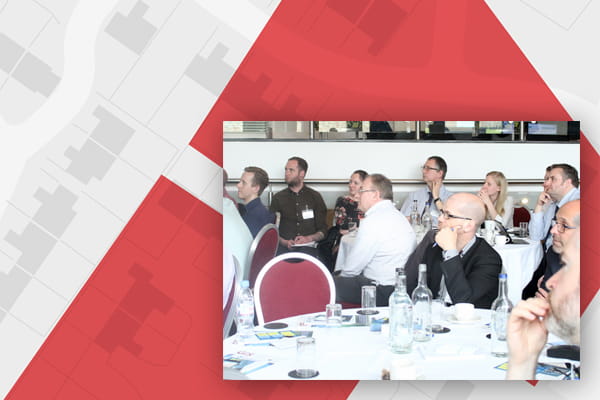 Local Government Cadcorp Conference image - people at tables with mapping background
