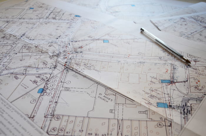 Photo of detailed mapping printed out with utility cables and pipes showing